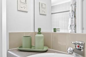 a bathroom with a sink and a bottle of soap at Cloud Nine City Centre 1BDR in Perth +25 photos