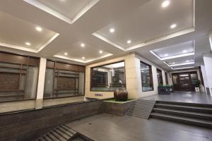 a lobby of a building with stairs and a vase at Abirami Residency in Pondicherry +98 photos