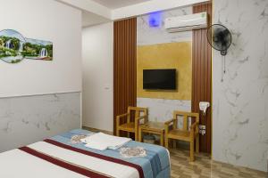 a hotel room with a bed and a tv at Nhà Nghỉ Thu Hằng 1 in Hà Ðông