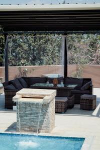 a patio with a couch and a fountain next to a pool at Villa Toni Mediterranean Family Lake Retreat in Star Dojran