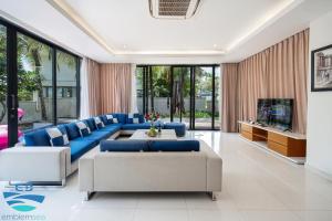 a living room with blue couches and a tv at Esea43 private pool villas in Danang