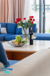 a table with a vase of flowers and a bottle of wine at Esea43 private pool villas in Danang