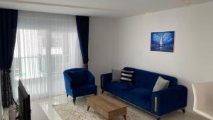 a living room with a blue couch and a chair at Cozy apartment for family vacation in Besthome 20 in Alanya