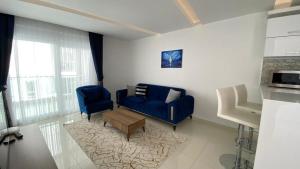 a living room with a blue couch and two chairs at Cozy apartment for family vacation in Besthome 20 in Alanya +13 photos
