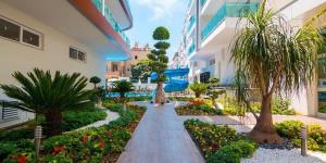 a garden in a building with palm trees and flowers at Cozy apartment for family vacation in Besthome 20 in Alanya