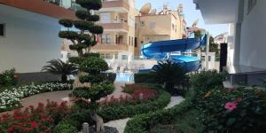 a garden with a slide in the middle of a building at Cozy apartment for family vacation in Besthome 20 in Alanya