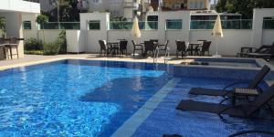 a large swimming pool with chairs and a table at Cozy apartment for family vacation in Besthome 20 in Alanya