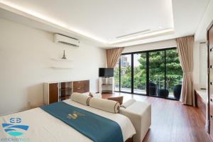 a bedroom with a large bed and large windows at Esea43 private pool villas in Danang +47 photos