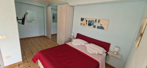 a bedroom with a red bed with two white pillows at Holiday Apartment Piazza Bacio Sublime in Fiumefreddo di Sicilia