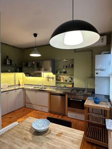 une cuisine avec des armoires blanches et un grand luminaire dans l'établissement 3 Bedroom, 2 Bathroom Fully Equipped House, à Istanbul 24 autres photos