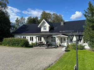 ÖverhörnäsHögsnäsgården的一栋带有黑色屋顶的白色房子