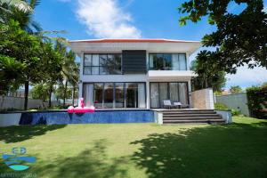 a house with a swimming pool in front of a yard at Esea43 private pool villas in Danang