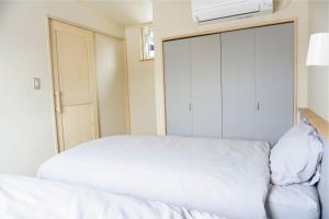 美瑛町にあるFarm Stay Chiyoda-Saraのクローゼット付きの客室の白いベッド1台