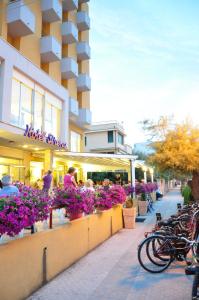 a building with flowers on the side of a sidewalk at Hotel Sirena in Senigallia