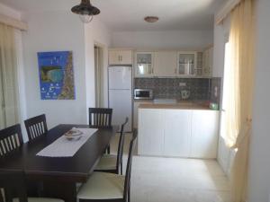 a kitchen and dining room with a table and a refrigerator at Paradisos House in Skiathos