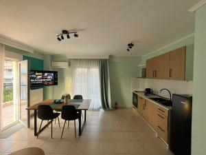 a kitchen with a table and chairs in a room at Odyssey Mare Steps from the Sea in Perea
