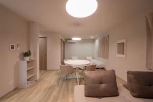 a living room with a table and chairs and a bed at ほうしんノマ HOUSHIN noma in Osaka