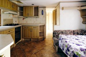a kitchen with wooden cabinets and a couch in a room at Siedlisko Pod Dębem in Wilimy