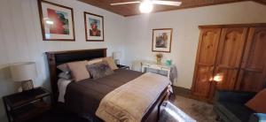 a bedroom with a bed and a wooden cabinet at Little Para Cottage Tanunda in Tanunda