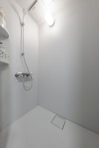 ein weißes Badezimmer mit Dusche und Waschbecken in der Unterkunft King Deer in Higashikawa