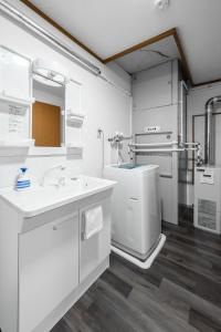 ein weißes Badezimmer mit Waschbecken und Badewanne in der Unterkunft King Deer in Higashikawa