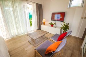 - un salon avec une table, des chaises et une télévision dans l'établissement Apartments Gardelin Superior, à Zadar