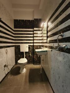 a bathroom with a toilet and a sink at After House South Opulent 5BHK Pool Mansion in Jaipur