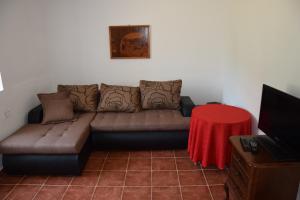 a couch in a living room with a red table at Beach House Buljarica in Petrovac na Moru
