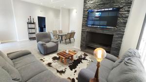 a living room with a couch and a fireplace at Dinas Accommodation House Oranjemund in Oranjemund