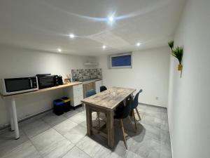 a kitchen with a wooden table and some chairs at Appartement atypique chaleureux in Rosières-devant-Bar