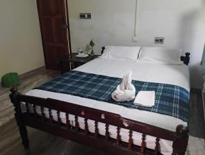 een slaapkamer met een bed met een handdoek erop bij Villa De Amore in Alleppey +8 foto's