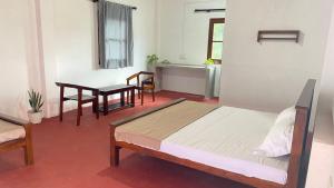 IbbagomuwaMapa Group Rest House的一间卧室,里面有一张床、一张桌子和几把椅子。