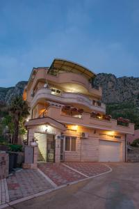 un gran edificio con un garaje delante en Apartments Nikolić, en Sveti Stefan