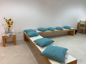 a room with two beds with blue pillows at Posada Eco-Ostello di Buggerru in Buggerru