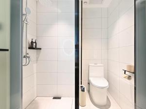a white bathroom with a toilet and a shower at CJIA APARTHOTEL Beijing Sanyuanqiao in Beijing +17 photos