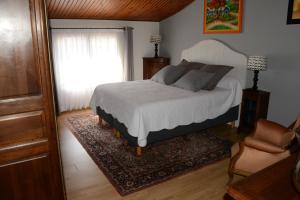 1 dormitorio con cama, ventana y alfombra en La Villa Léa, en Uzès