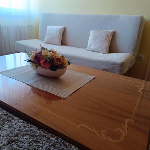 a bowl of flowers sitting on a coffee table at Sweet Home Apartman in Nyíregyháza
