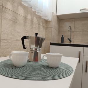 two coffee cups sitting on a counter in a kitchen at Sweet Home Apartman in Nyíregyháza