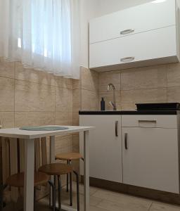 a kitchen with a table and two stools at Sweet Home Apartman in Nyíregyháza +10 photos