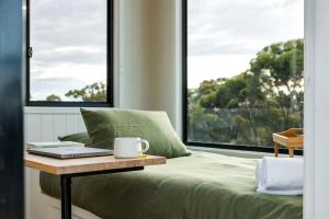 a bedroom with a bed with a table with a laptop on it at Lovely Tiny House with Barbecue in Maiden Gully, Victoria in Woodvale