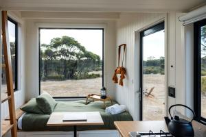 a room with a bed and a large window at Lovely Tiny House with Barbecue in Maiden Gully, Victoria in Woodvale