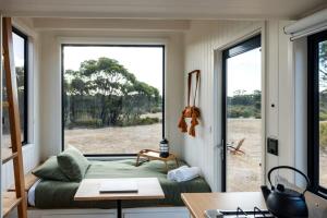 a room with a bed and a large window at Lovely Tiny House with Barbecue in Maiden Gully, Victoria in Woodvale