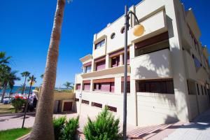 a building with a palm tree in front of it at Burriana Beach Apartment in Nerja