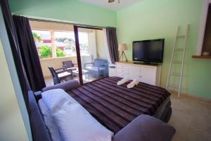 a bedroom with a bed with a couch and a tv at Burriana Beach Apartment in Nerja