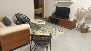 een woonkamer met een bank en een tv bij Moon Flower, Pereybere in Grand Baie +2 foto's
