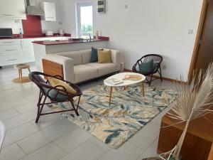 een woonkamer met een bank, een tafel en stoelen bij Moon Flower, Pereybere in Grand Baie