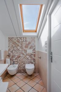 ein Badezimmer mit einem Dachfenster, einem WC und einem Waschbecken in der Unterkunft Palazzo Gargiulo Luxury in Sorrent