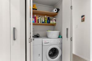 a laundry room with a washer and dryer at Seaview - Mangawhai Heads Holiday Home in Mangawhai