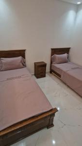 two beds sitting next to each other in a room at Escale calme et moderne in Oulad Akkou