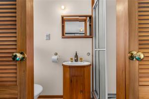 a bathroom with a sink and a mirror at Chillax - Mangawhai Heads Holiday Home in Mangawhai +18 photos